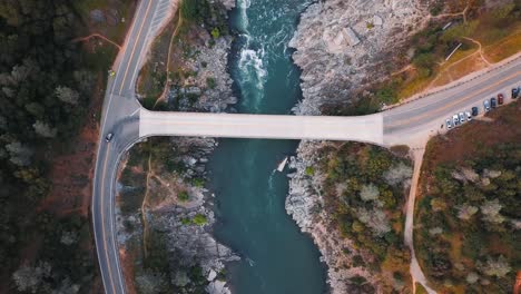 drone looking over car bridge river crossing in northern california