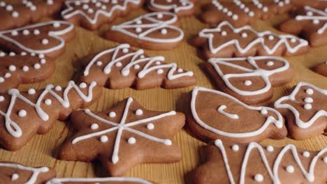 decorating gingerbread cookies for christmas, closeup macro shot making handmade festive new year sweets and cookies with white glaze icing