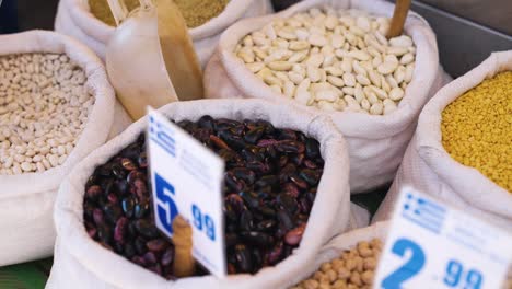 variety of fresh beans, lentils, and legumes on sale at a market