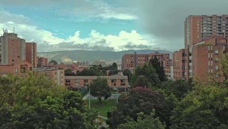 Un-Dron-Volando-Entre-Edificios-Con-Una-Montaña-Al-Fondo