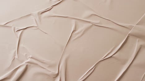 Video-of-close-up-of-beige-creased-fabric-with-copy-space