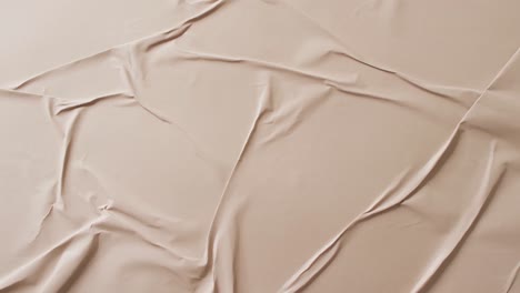 video of close up of beige creased fabric with copy space