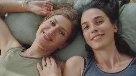 portrait of happy lesbian couple on bed