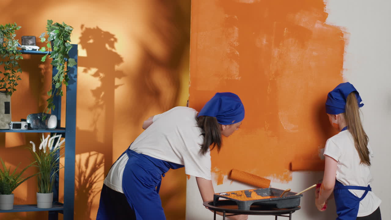 Family painting a wall orange