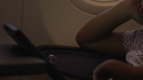 Close-up-view-of-small-boy-playing-with-touch-pad-on-the-table-in-aircraft