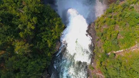 Beautiful-water-fall-through-forest-cliff-on-a-sunny-day-4k