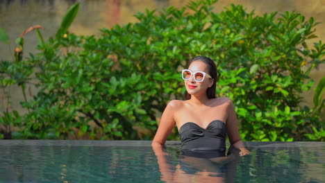 Tentadora-Mujer-Exótica-Sexy-En-La-Piscina-Disfrutando-En-Un-Caluroso-Día-De-Verano,-Mirando-La-Cámara,-Cámara-Lenta-De-Marco-Completo