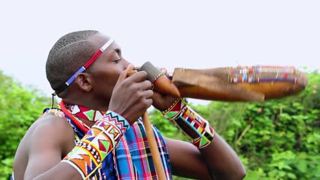 Masai-man-drinking-milk,-wearing-a-traditional-clothing,-bright-overcast-day