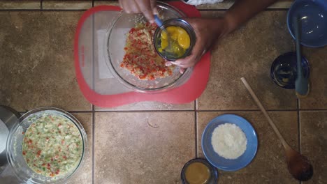 mixing eggs into a traditional recipe for homemade meatloaf - top-down view