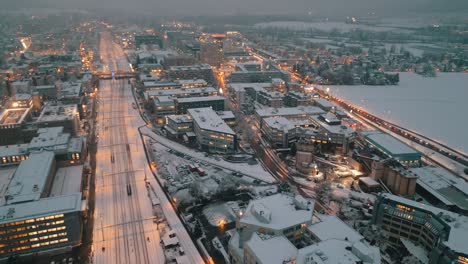 Snowy-urban-dusk:-Aerial-view-of-traffic-on-city-streets-lit-by-evening-lights