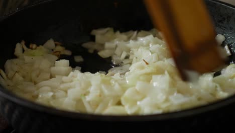freír cebollas en una sartén con aceite. agitar la cebolla en la sarté con una espátula de madera