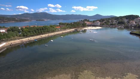 aerial pan right view across esteiro mainer with boats moored on clear sunny day