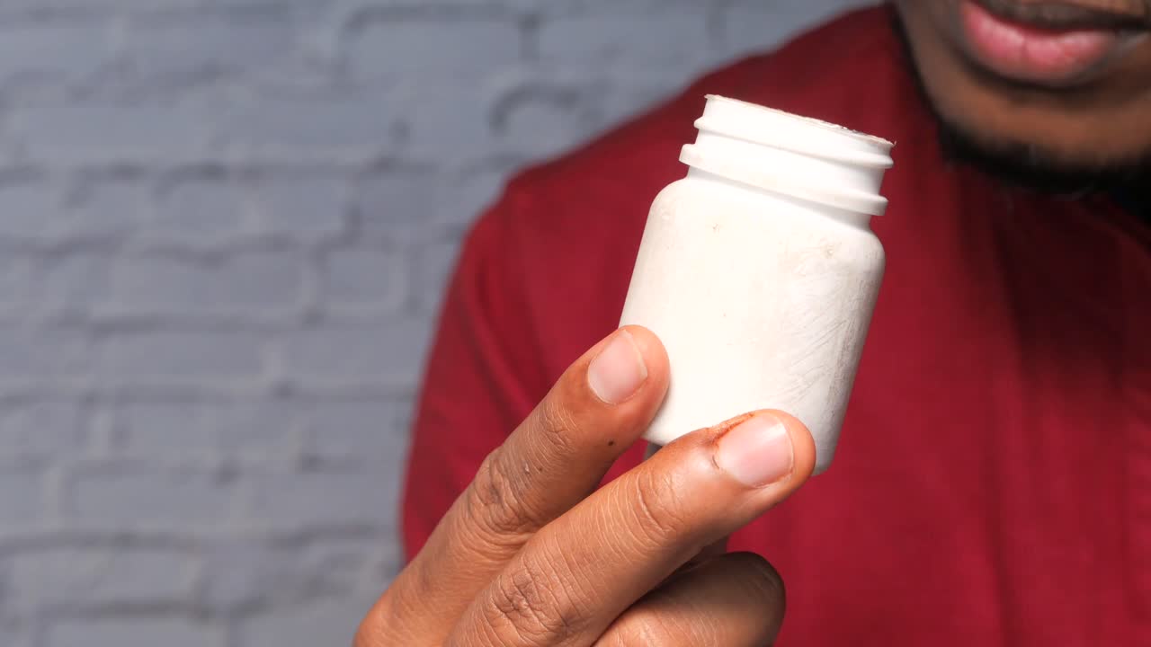 persona que sostiene un frasco de medicamento