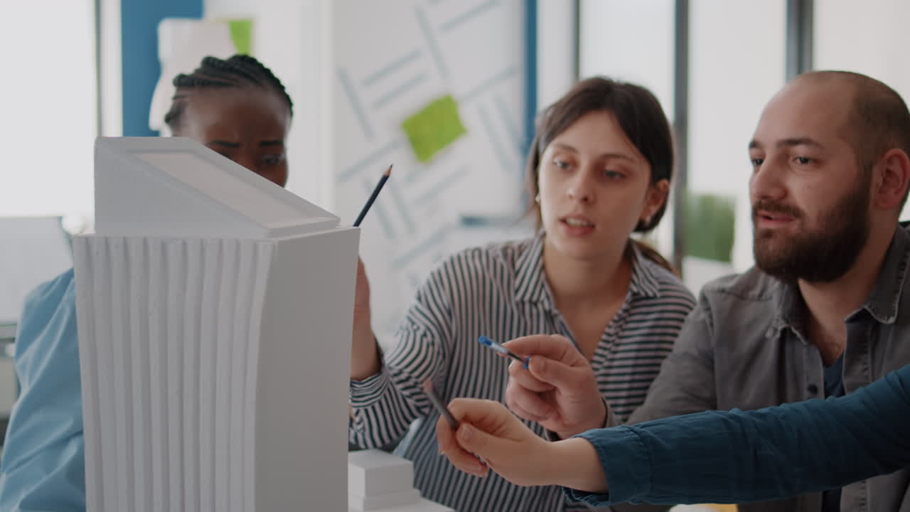 Architects collaborating on a building model in an office