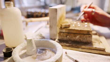 Close-Up-Of-Female-Jeweller-Putting-Solder-Onto-Pieces-In-Studio