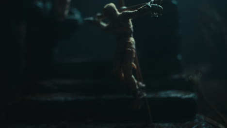 a miniature mummified doll hanging on the gallows at night