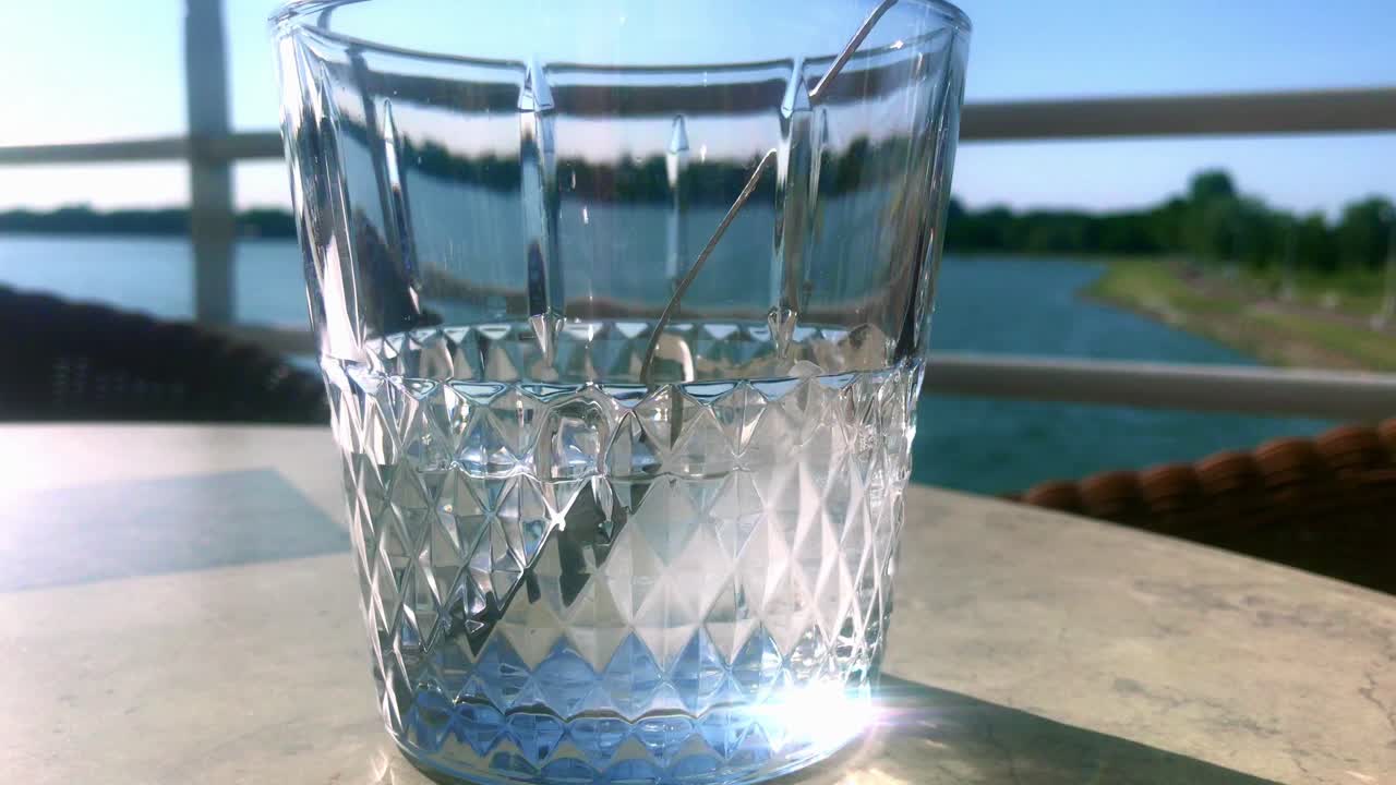 Close-up view of water glass with sun reflection shiny glitter