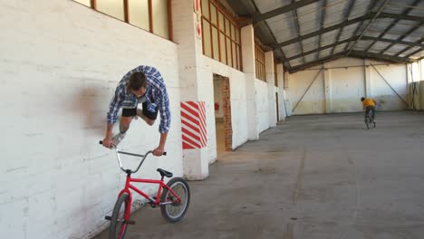 bmx riders in an empty warehouse