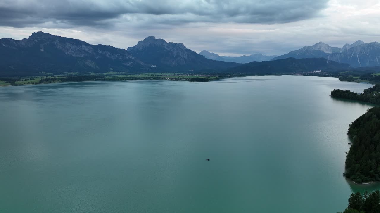 vuelo de drones sobre un gran lago en la cordillera y un pequeño barco en primer plano