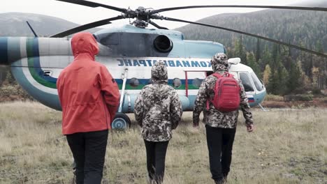 people near a helicopter in a remote location