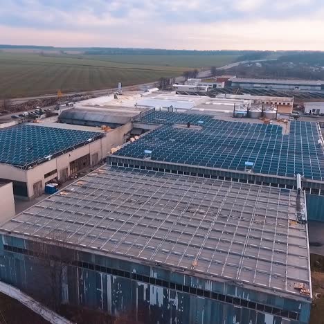 solar farm on rooftop of buildings. blue solar panels for sustainable source of energy in the countryside. aerial view.