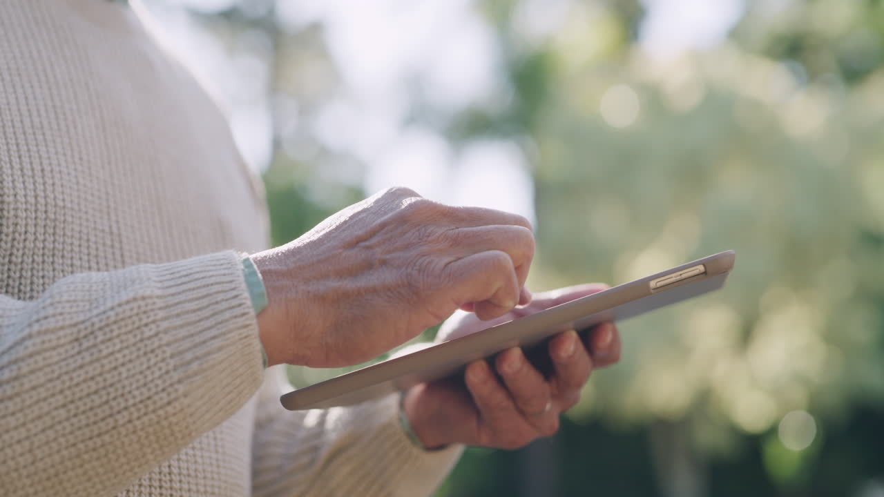 anciano usando una tableta al aire libre