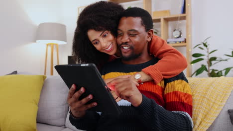 Black-couple,-tablet-and-hug-by-sofa-in-home