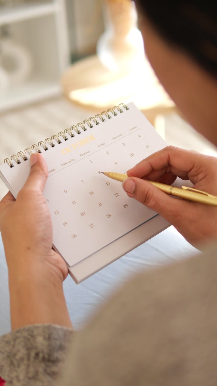 Close-up of Hands Planning Schedule on a Desk Calendar
