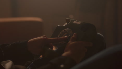 hands of man dialing vintage rotary phone in softly lit room