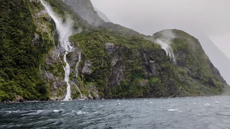 fotografía de perspectiva turística de una cascada que fluye por los acantilados en un viento fuerte