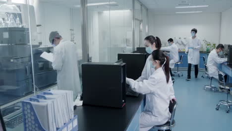 biotechnology scientists or researchers working together in biological laboratory, carrying out experiments, analyzing their findings using microscope, test tubes and advanced equipment for analysis