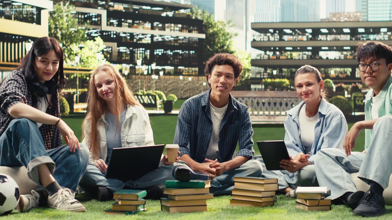 Portrait of classmates in study session sitting on campus lawn