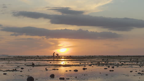 kids catching fish in a low tide sunset in philippines