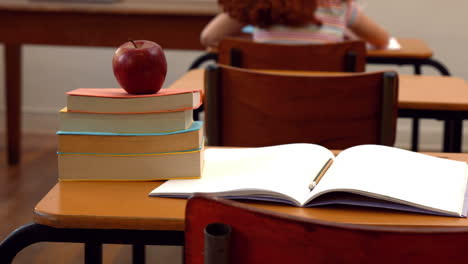 Apple-and-books-on-desk-in-classroom