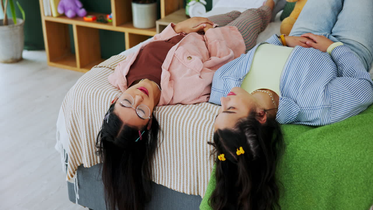 Two young women lying on a bed