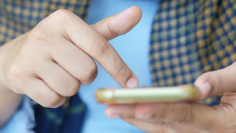 Cerca de la mano de la mujer sosteniendo un teléfono inteligente.