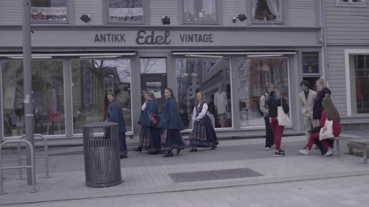 Female High School Students In Traditional Clothing Walk On The Concourse In Tromso, Norway During Norwegian Constitution Day. tracking shot