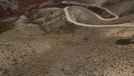 drone video of a route that crosses meadows and mountains in autumn