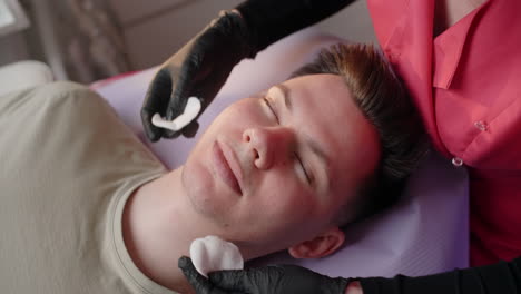 man receiving facial treatment at spa