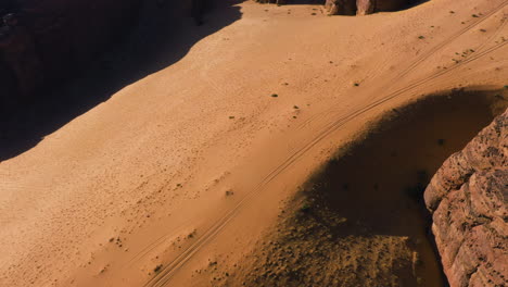 Drone-shot-tilting-over-a-sandstone-canyon,-sunny-evening-in-Saudi-Arabia