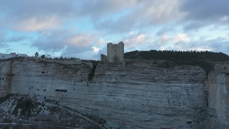 Ascending-drone-movement-the-castle-of-the-medieval-village-of-Alcalá-del-Jucar,-Spain,-one-of-the-most-beautiful-villages-in-Spain