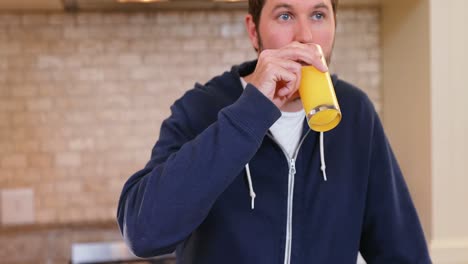 hombre vertiendo jugo en un vaso y teniendo en la cocina 4k 4k