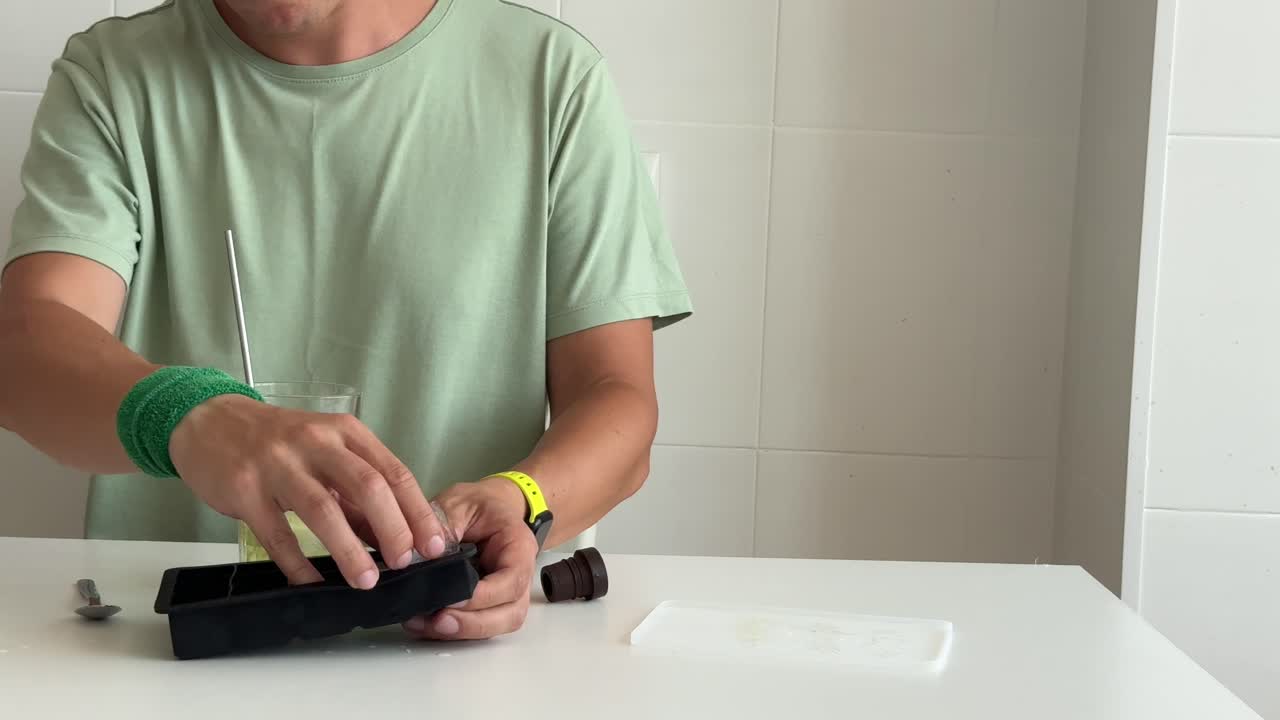 Man Making and Drinking a Refreshing Cold Beverage with Ice