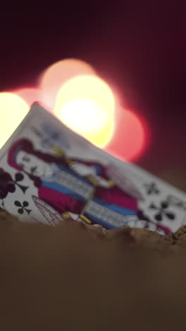 a jack of clubs playing card in the sand