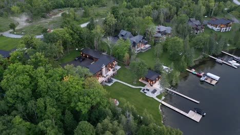 beautiful houses with jetty in tranquil lake - aerial shot