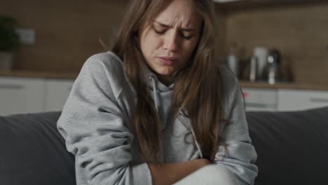 Caucasian-woman-with-anorexia-sitting-with-huge-pain-at-the-couch.