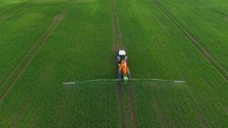 pesticide and fertilizer spraying on the field aerial view with tractor