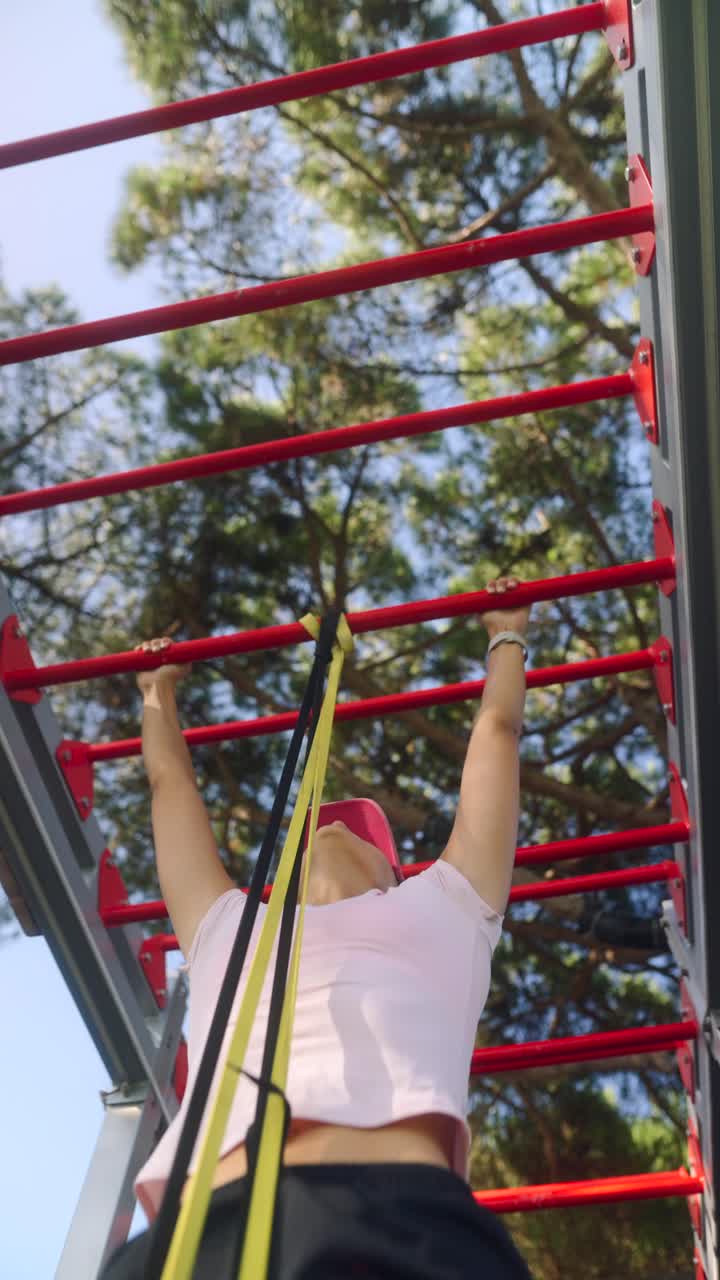 Woman working out on outdoor exercise equipment