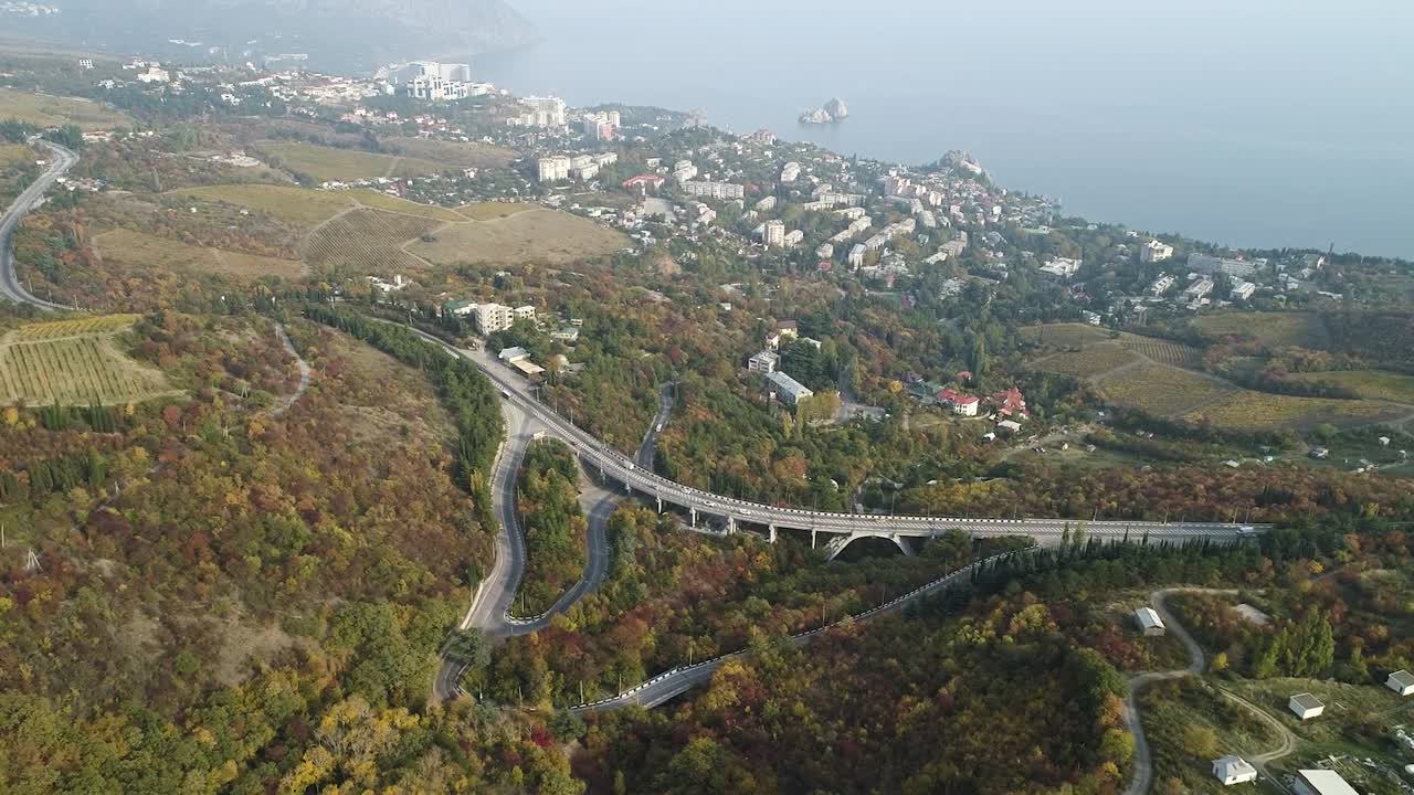 다리와 도시 전망을 가진 가을 산길