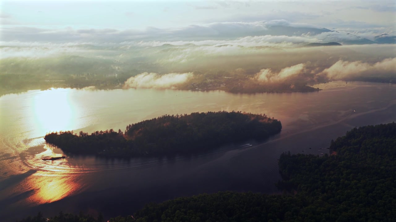 Two jet skis Lake Schroon Clarks Island ummer golden hour sunset mist low clouds aerial drone harbor view Up State New York landscape Town of Schroon Lake Pharaoh Mtn Adirondack Mountains circle left
